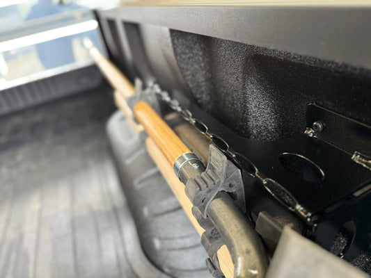Shovel being held in place by steel tool mount in back of truck.