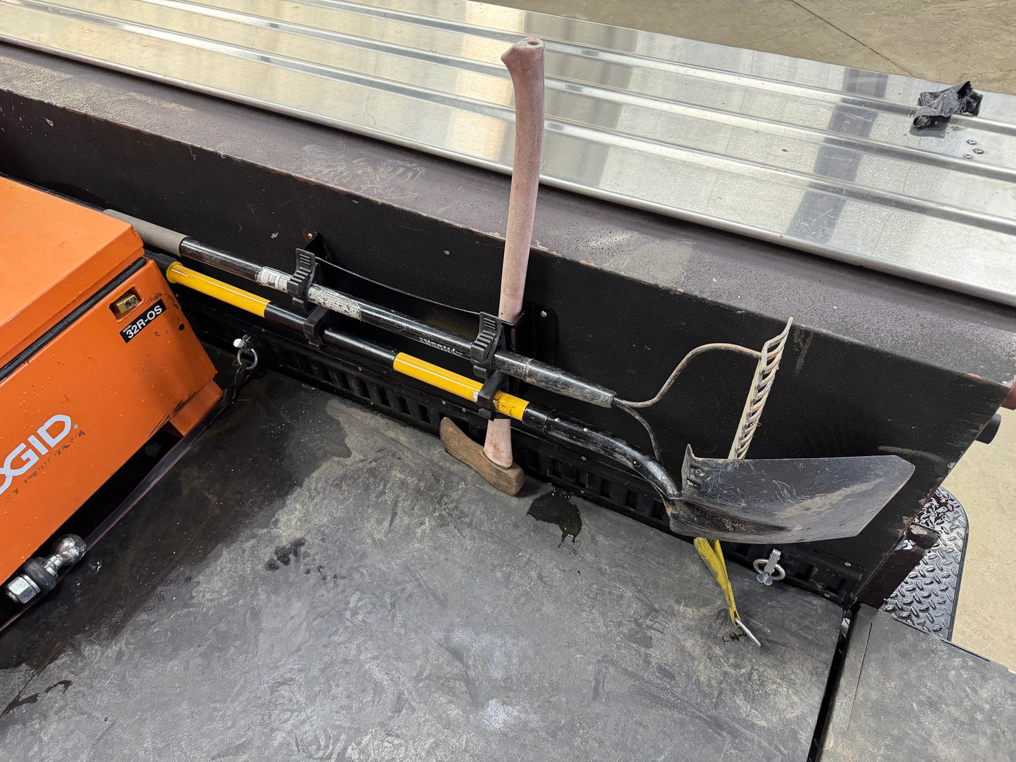 Fire Tool holder mounted on Truck bed. Quick release holding there tools, a fire ax, heavy duty rake, and flat shovel.
