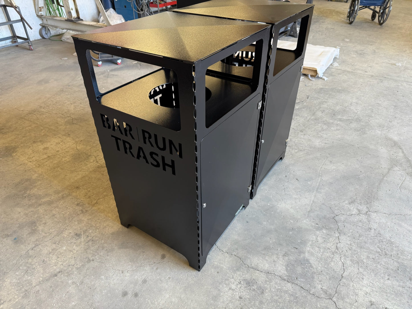 Heavy duty all weather commercial trash can with black powder coat on fab floor.