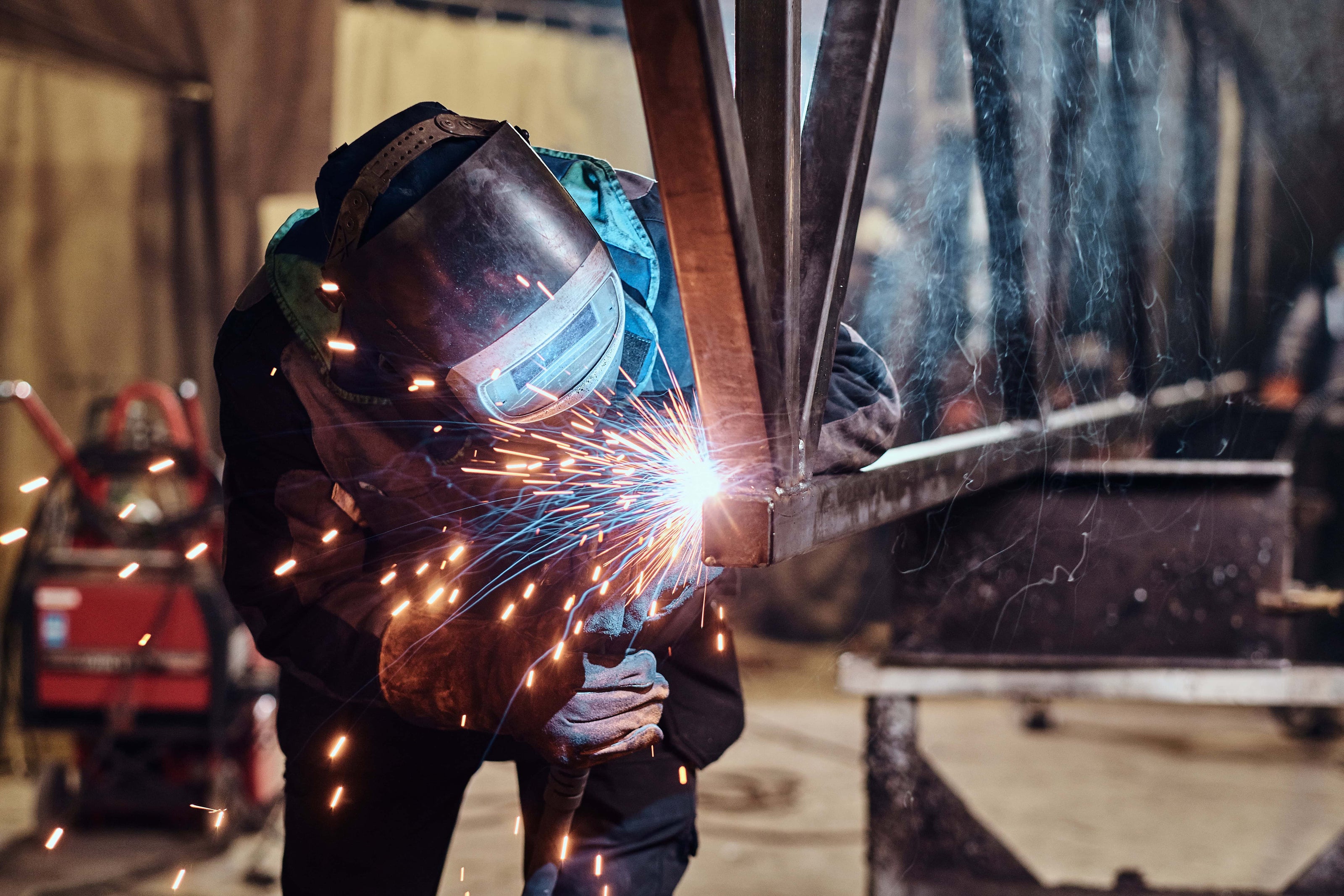 Person welding metal in fabrication shop roseburg Oregon. Gheer Built