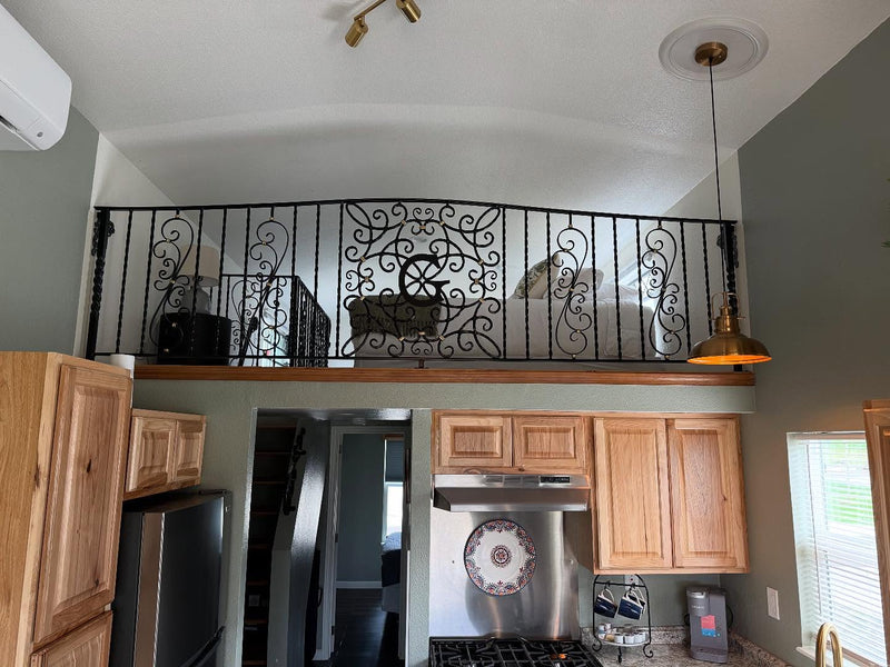 Metal handrail with G monogram overlooking a kitchen